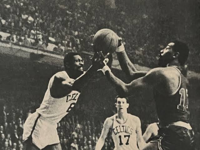 American basketball player Wilt Chamberlain (right) battling Bill Russell (center)